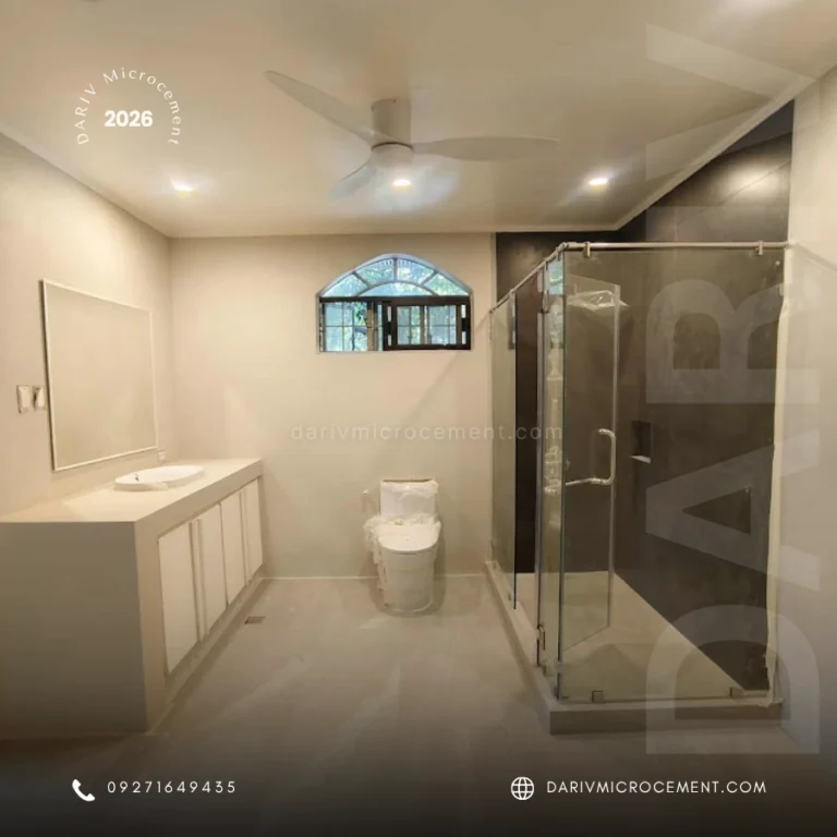 Modern bathroom with white vanity, sink, mirror, small arched window, and a glass-enclosed shower.